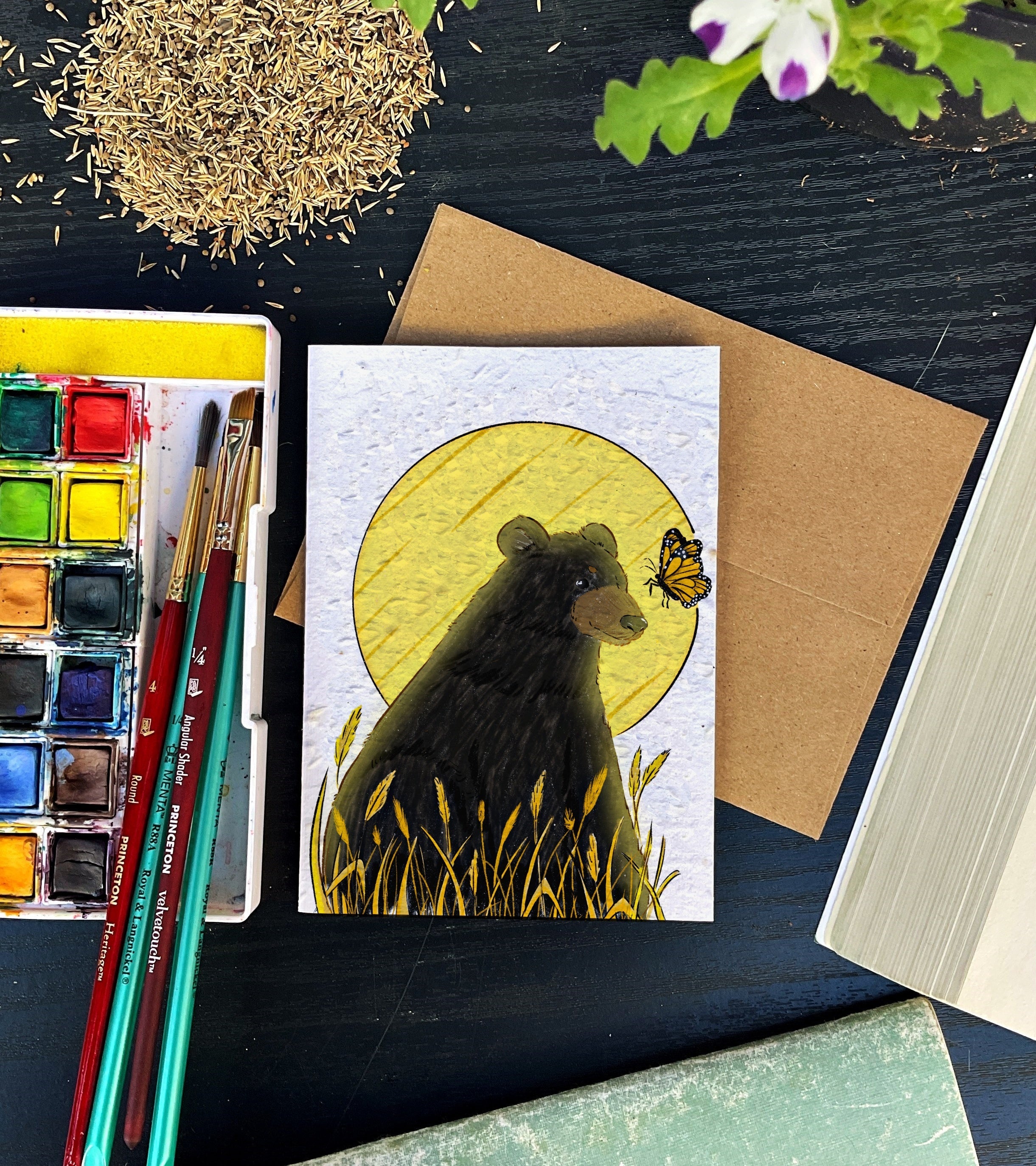 A bear and a butterfly in a field of wheat under a full moon greeting card. 